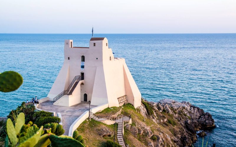 Torre costiera bianca su una scogliera affacciata sul mare.